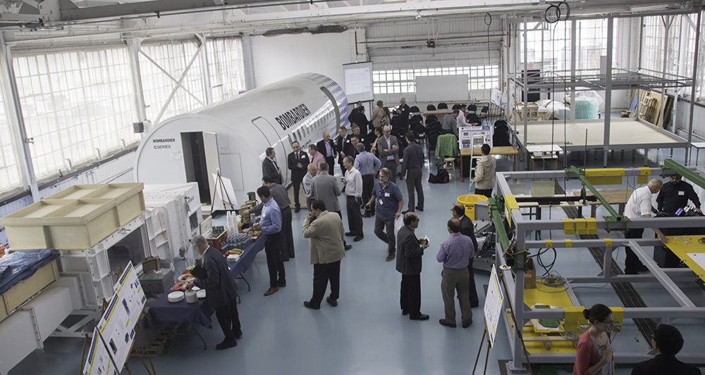 A group of researchers network in the TMU Aerospace Engineering Centre facility