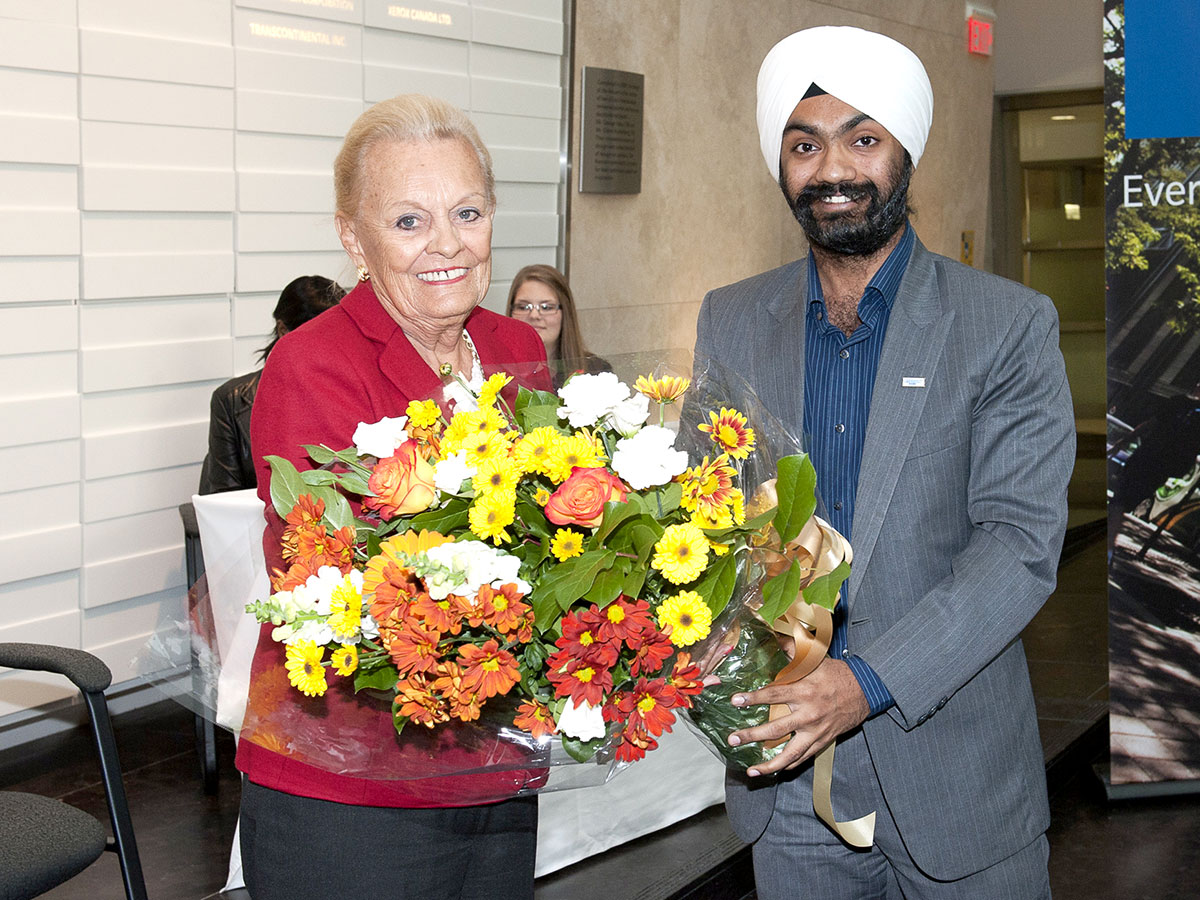 Loretta Rogers holds a large bouquet of flowers with student award winner Parvinder Sachdeva in 2013.